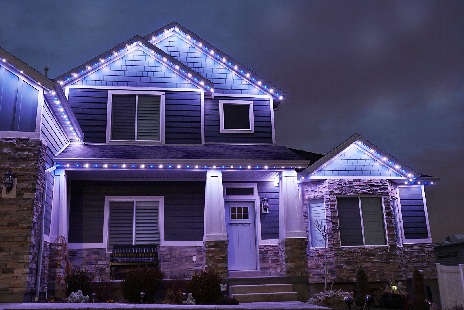Blue and white permanent lighting outlining a two-story home