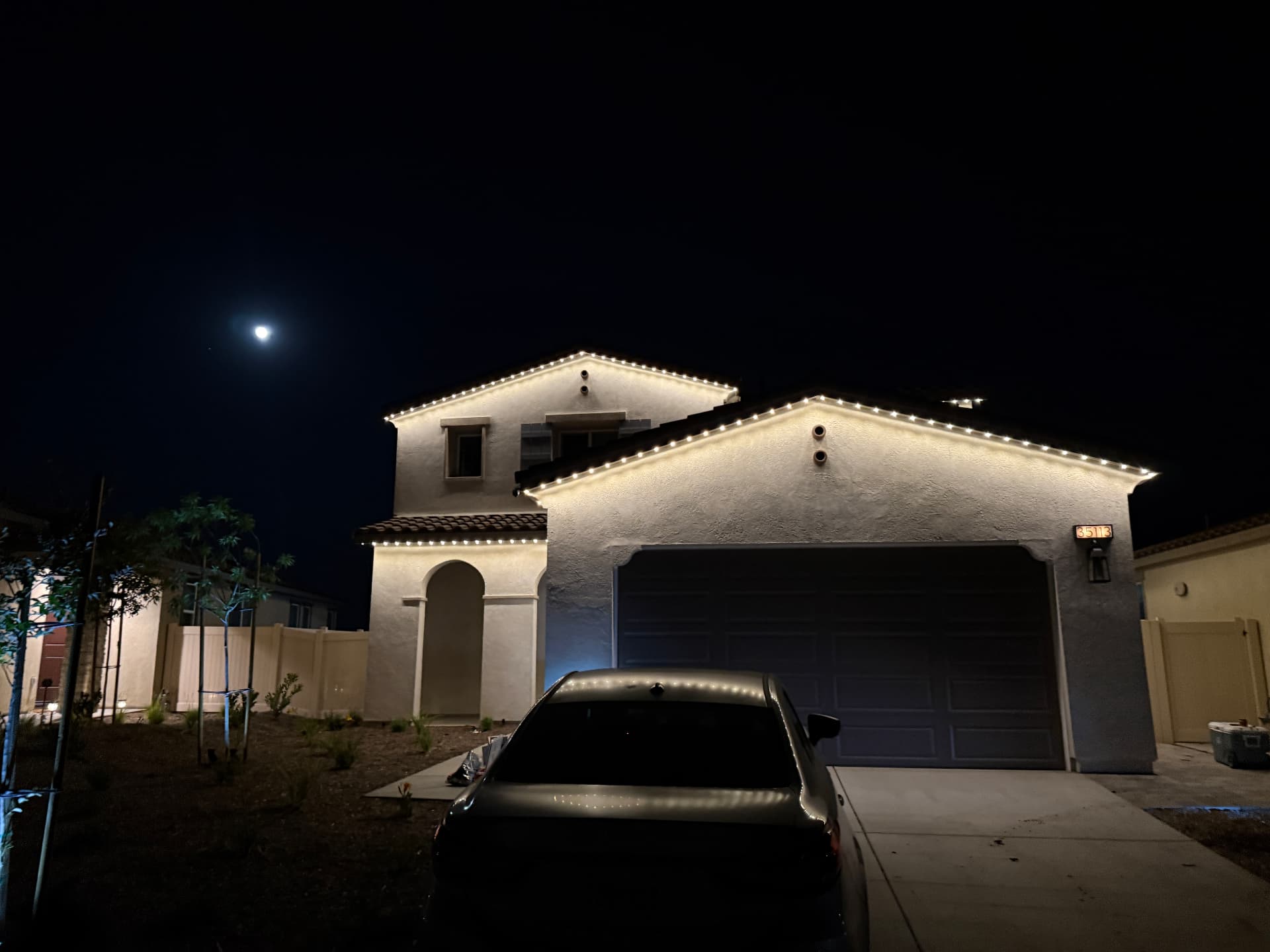 Warm white permanent lighting outlining a two-story home