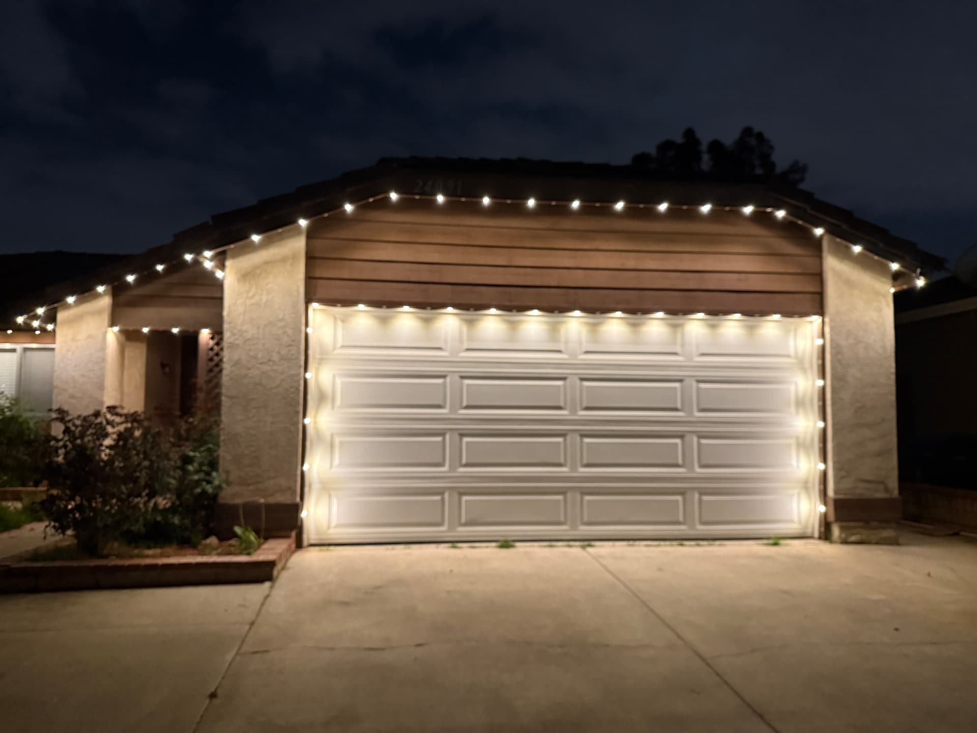 Soft warm permanent lighting outlining a single-story home