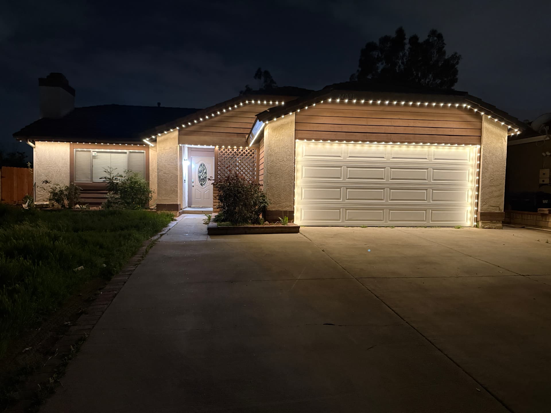 Warm white permanent lighting outlining a luxury home