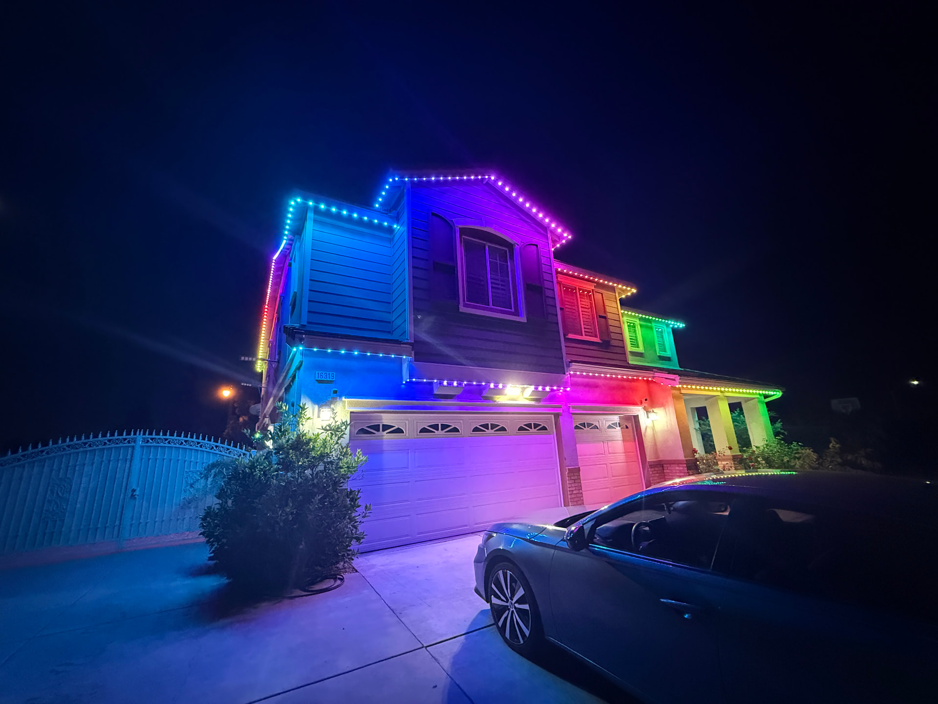 Rainbow permanent lighting across a two-story home's roofline